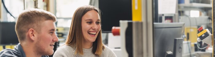 Ein Student und eine Studentin arbeiten gemeinsam an einem Projekt im Labor und lachen. | © Lamprecht