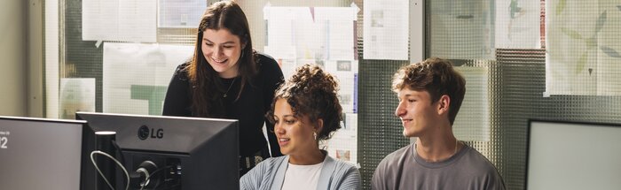 Drei Studierende schauen gemeinsam auf einen PC-Bildschirm und arbeiten konzentriert zusammen. | © Lamprecht