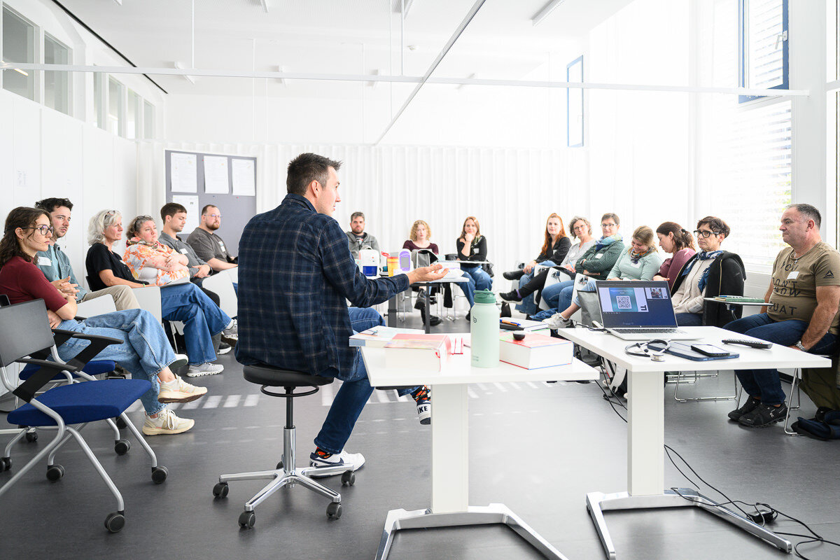 Menschen sitzen im Stuhlkreis und hören interessiert dem Redner zu. | © Matthias Rhomberg | FHV