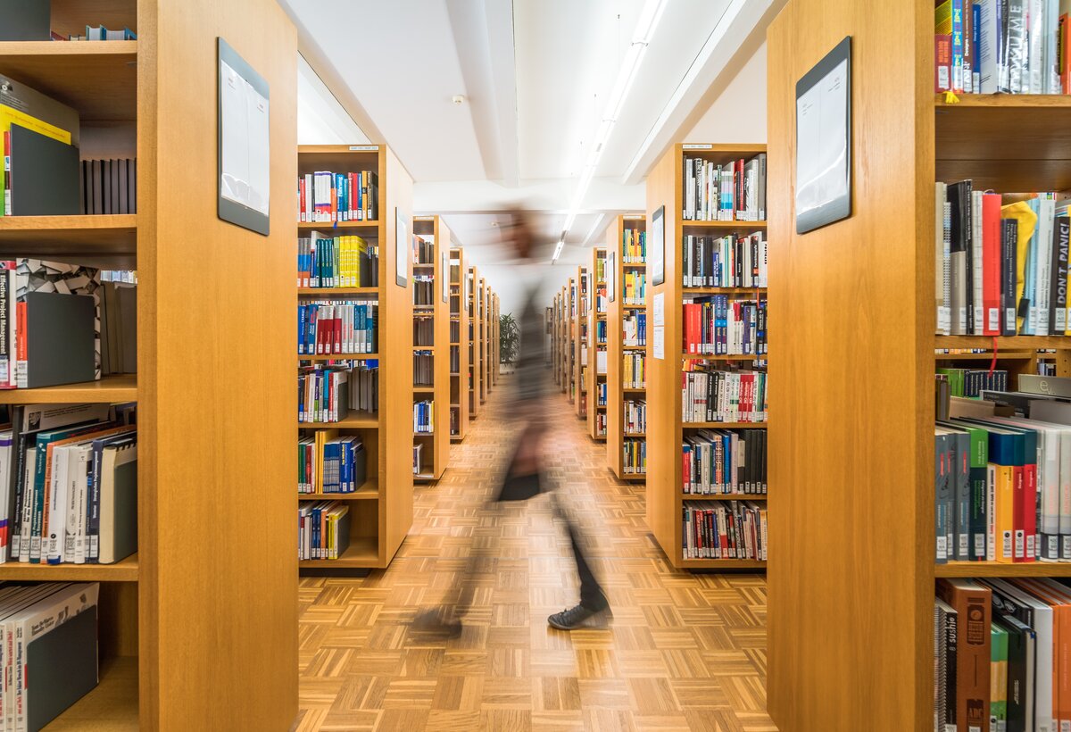 Benutzerin geht in der Bibliothek durch die Regale | © Fabrizio Prizi