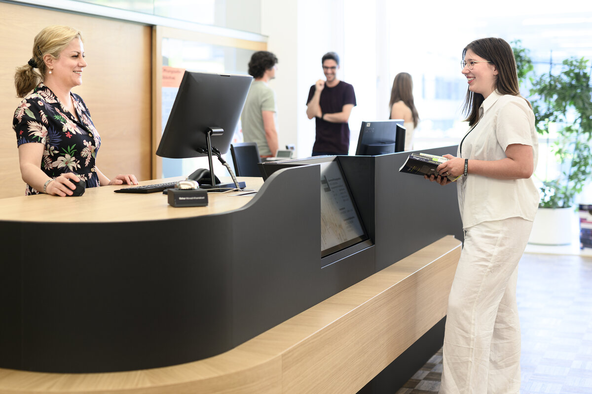 Studentin wird an der Infotheke bei der Bibliothek beraten | © Matthias Rhomberg & FHV