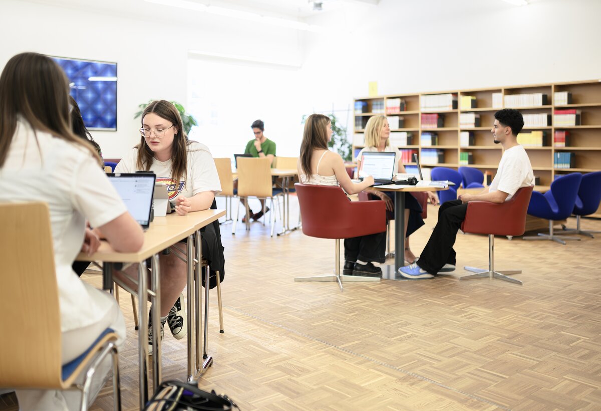Students sit in the magazine area of the library. | © Matthias Rohmberg & FHV