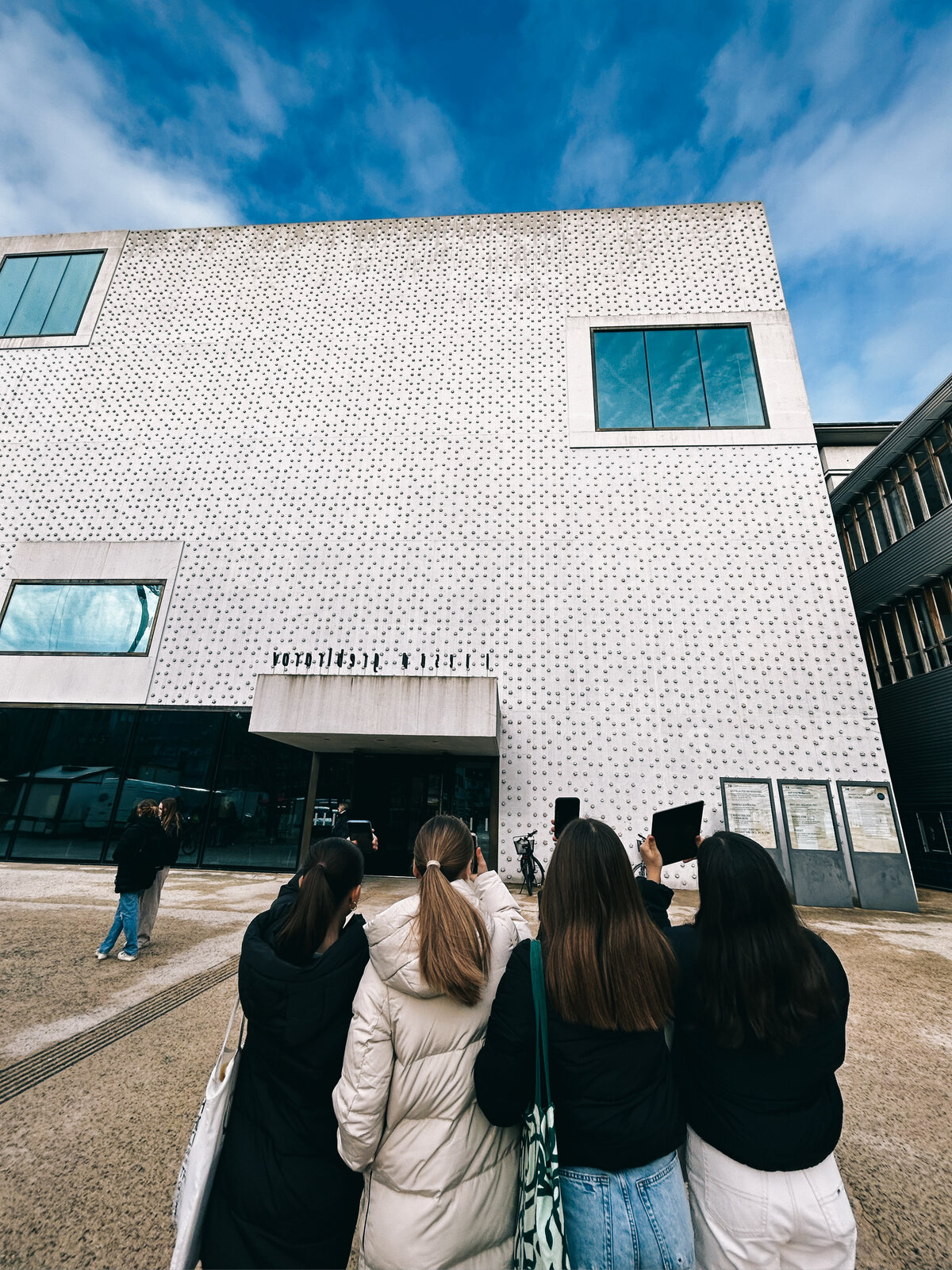 Three students hold their smartphones up to the front of the Vorarlberg Museum | © FHV