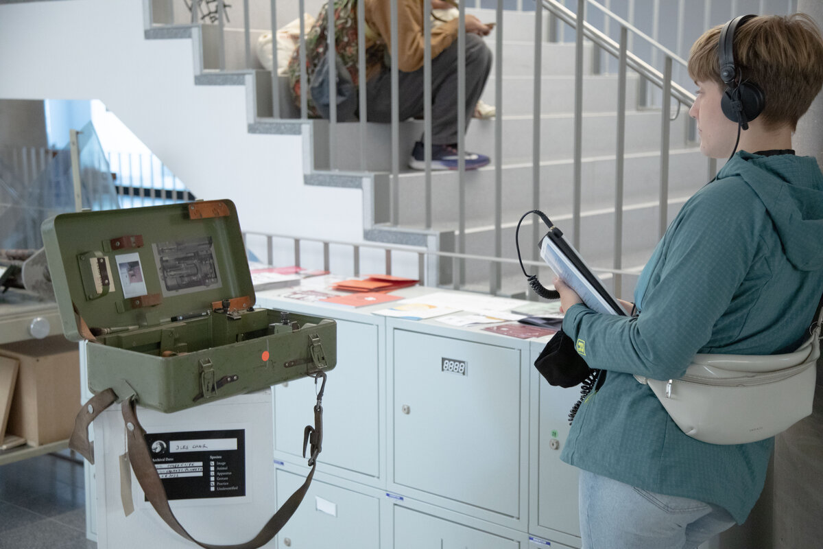 Audiowalk - person with headphones in front of an artefact  | © FHV