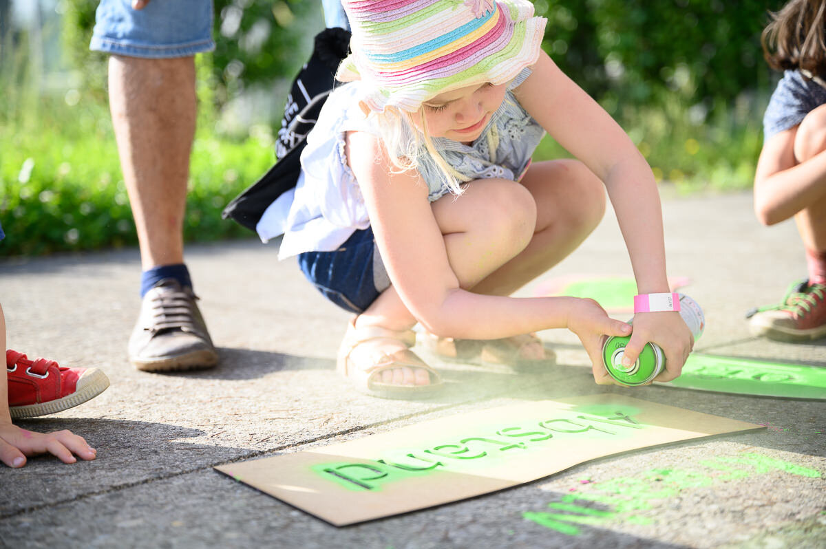 Little girl sprays green paint on asphalt | © Matthias Rhomberg & FHV