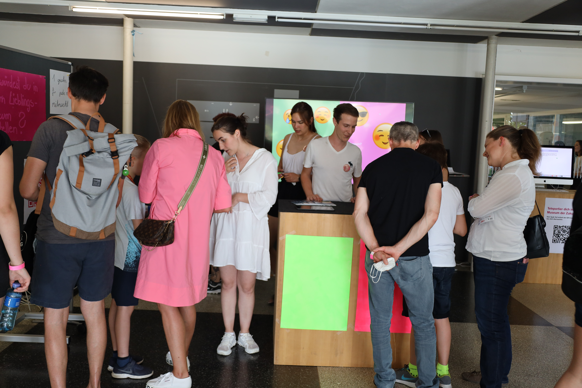 People in the foyer take a look at the various stands of the Design department. | © Vicky Mueller & FHV