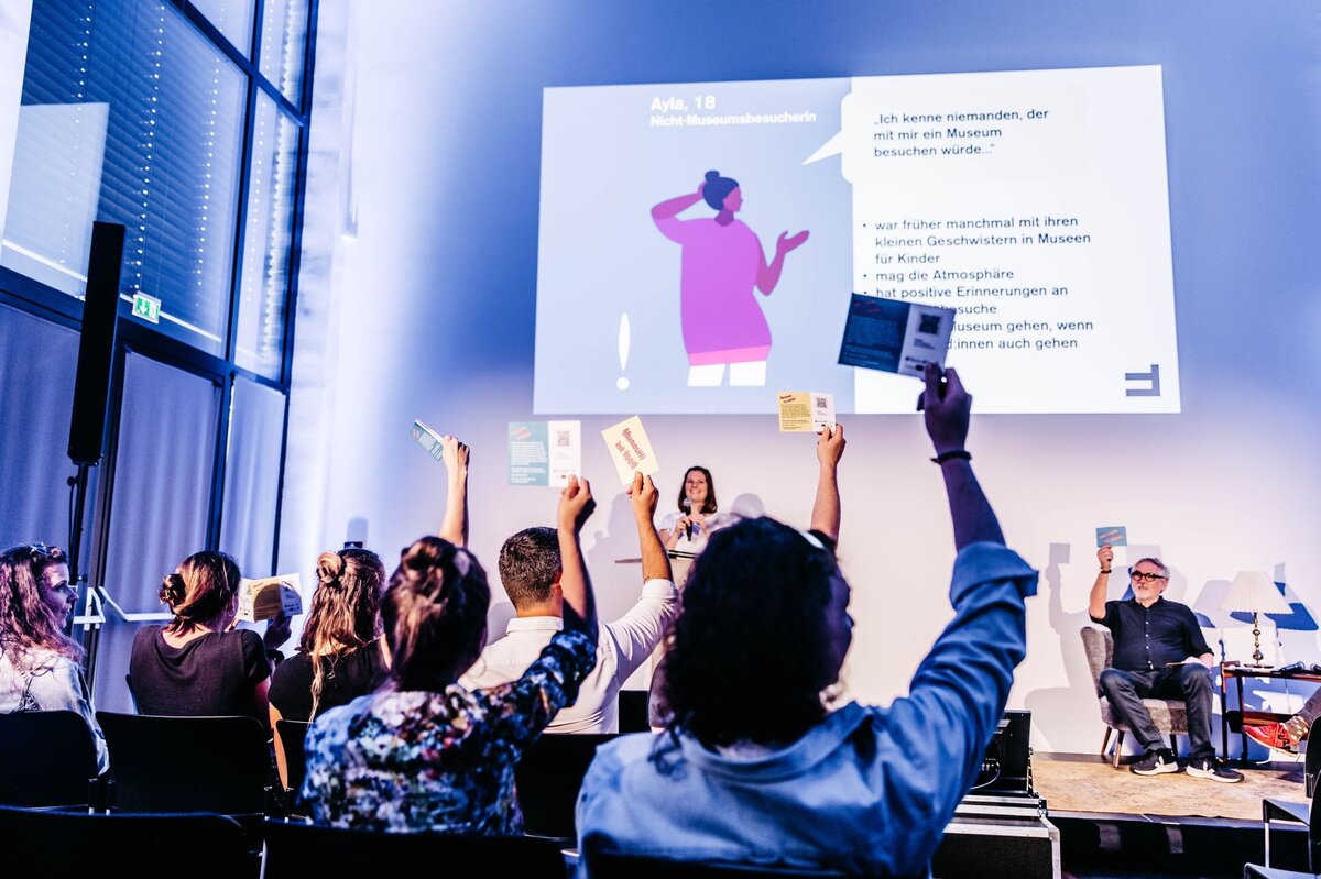 Audience holds cards in the air | © FHV