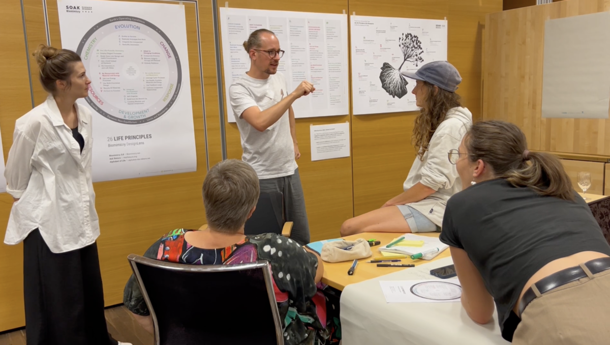 Unterschiedliche Menschen diskutieren vor diversen Plakaten | © Fachbereich Gestaltung, FHV