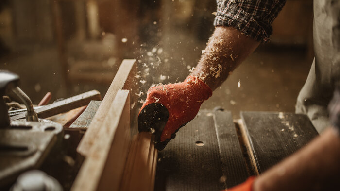 Hand an einer Holzsäge | © Adobe Stock