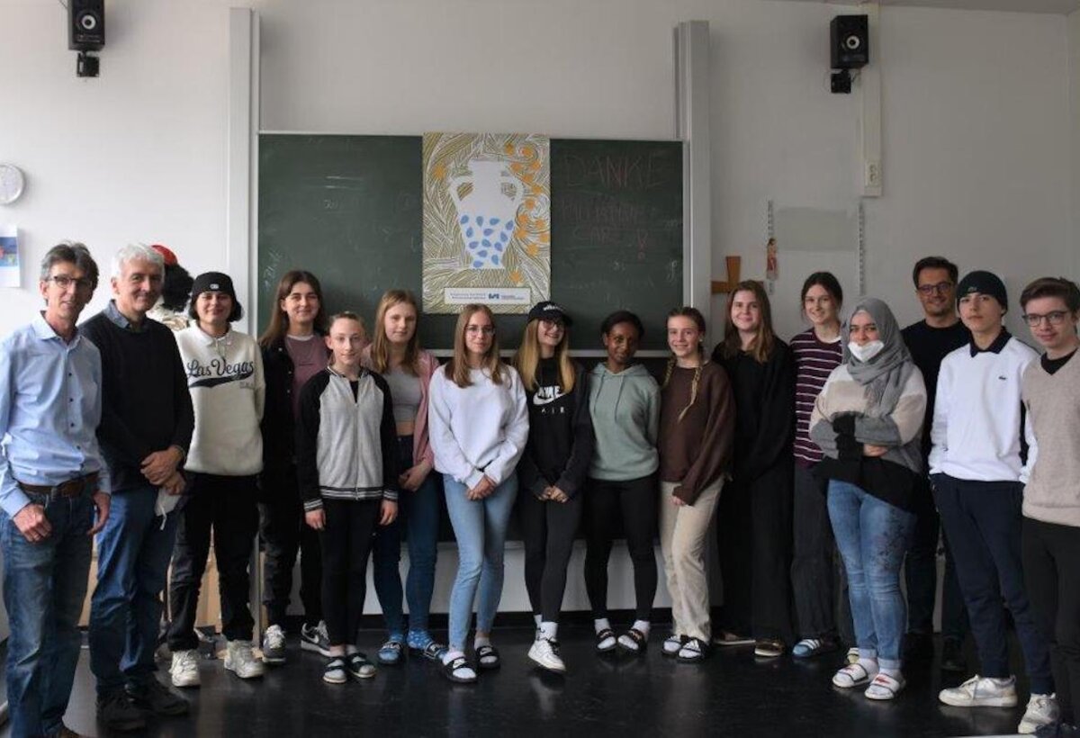 Eine Schulklasse steht vor einer Tafel