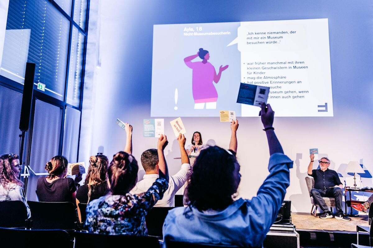 Ein Saal mit Menschen, wo eine Präsentation stattfindet. | © FHV