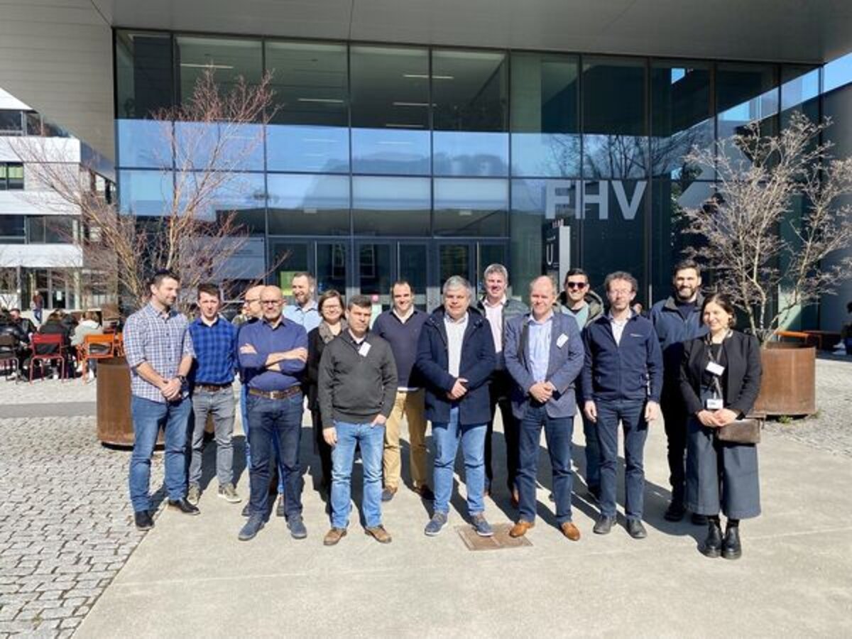 Eine Menschengruppe steht vor einem Gebäude. | © FHV