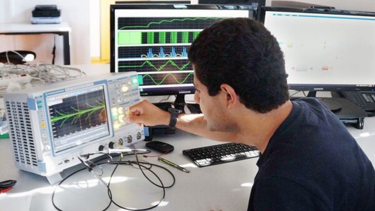 Ein Mann sitzt vor einem Forschungsinstrument und testet. | © V-Research