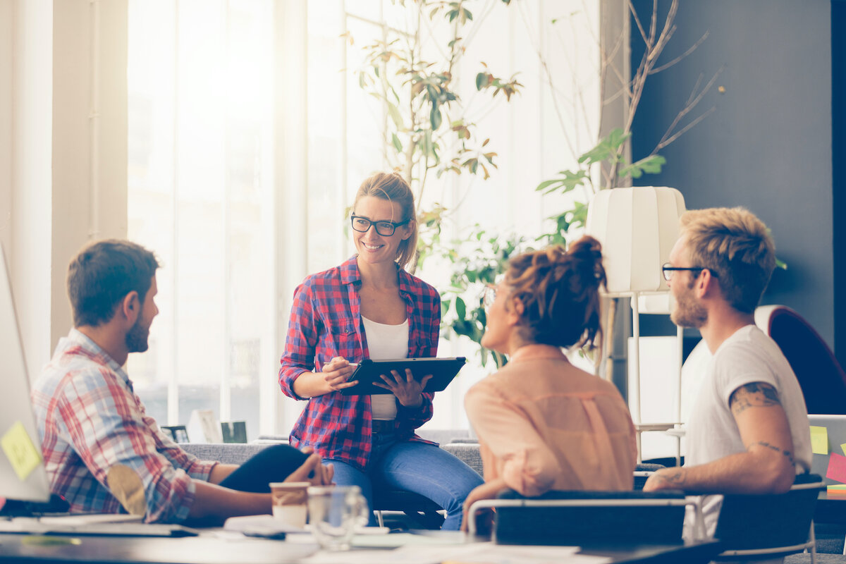 Eine Gruppe von Menschen sitzt im Gespräch zusammen und arbeitet gemeinsam. | © Adobe Stock