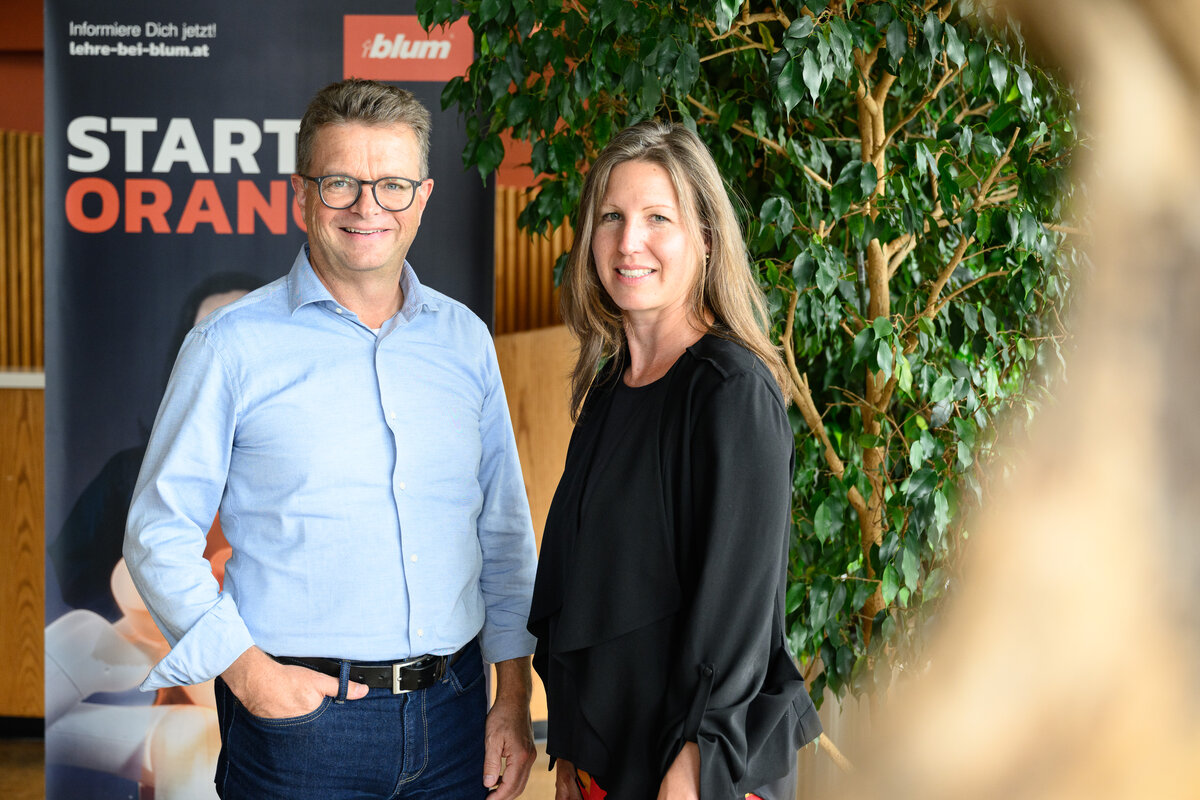 Sabrina Schneider und Klaus Wendel stehen vor einem Plakat und einer Pflanze. | © Rhomberg