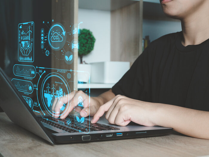 IoT Sustainability Lab | © Adobe Stock Hellwig Mensch sitzt am Computer und Hologramme die verschiedene Umwelt daten anzeigen scheinen auf. | © Adobe Stock Hellwig
