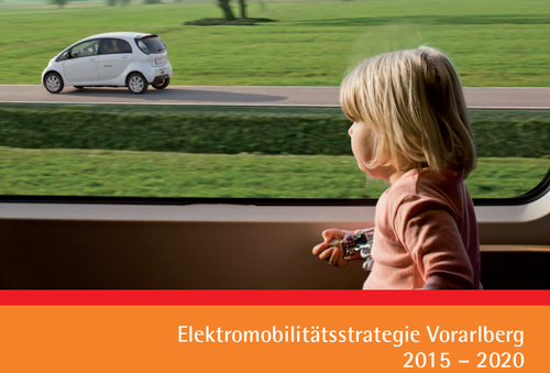 Ein Kind mit bloden Haaren sitzt im Zug am Fenster und sieht ein weißes E-Auto