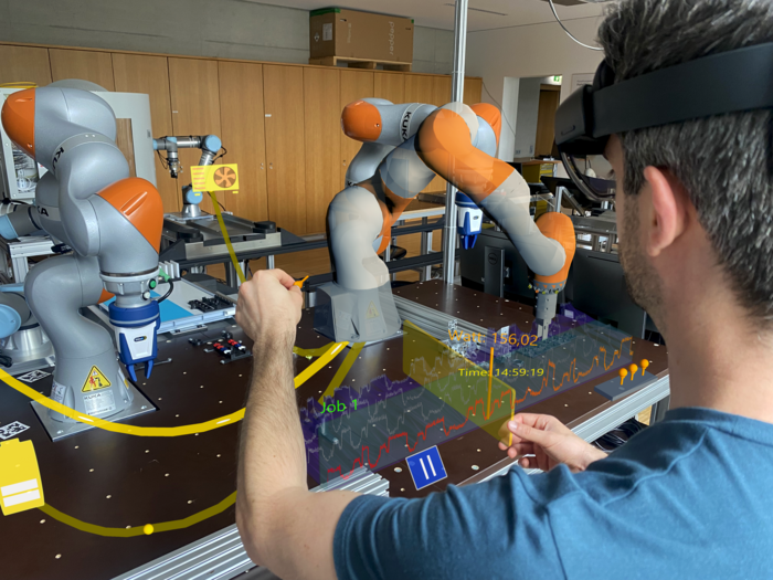 Darstellung des digitalen Zwillings mittels Augmented Reality Technologien | © FHV Ein Mann mit einer VR-Brille bedient einen Roboterarm | © FHV
