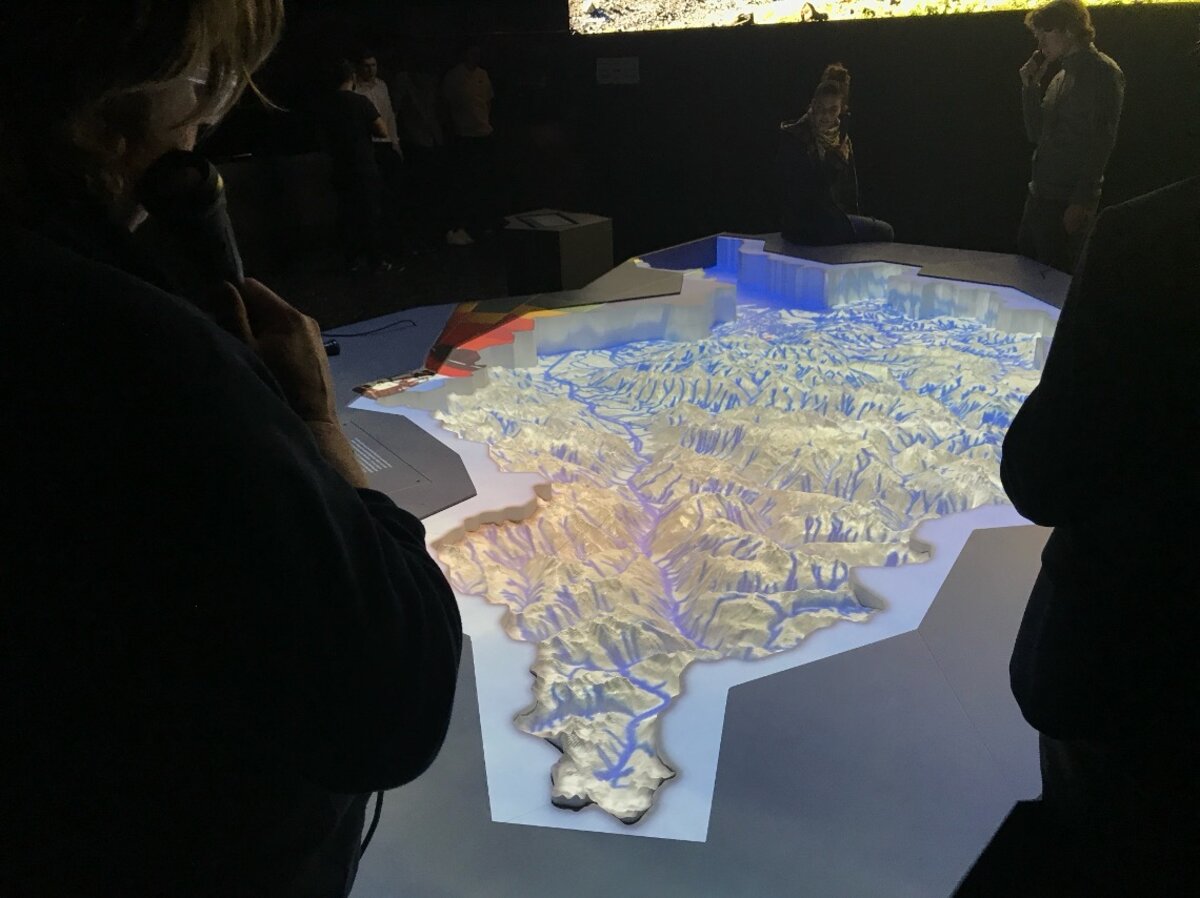 Ein dreidimensionales Landschaftsmodell in einem Museum zeigt detaillierte Bergerhöhungen, geschwungene Flussläufe und mehrere Seen. | © FHV