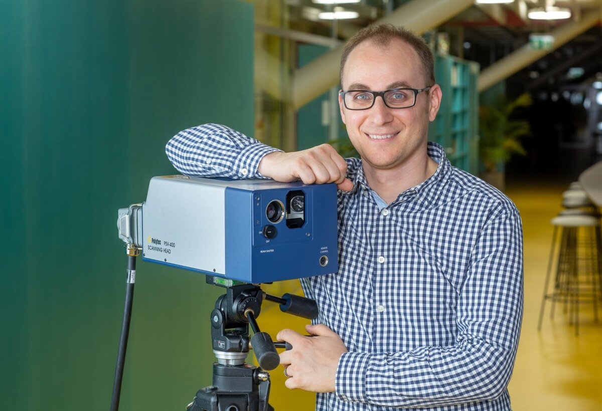 Ein Mann posiert mit einem Laser 