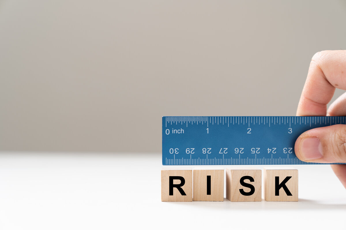 Blaue Lineal-Skala über dem Wort „Risk“ als Symbol für die Risikobewertung. | © Kenishirotie