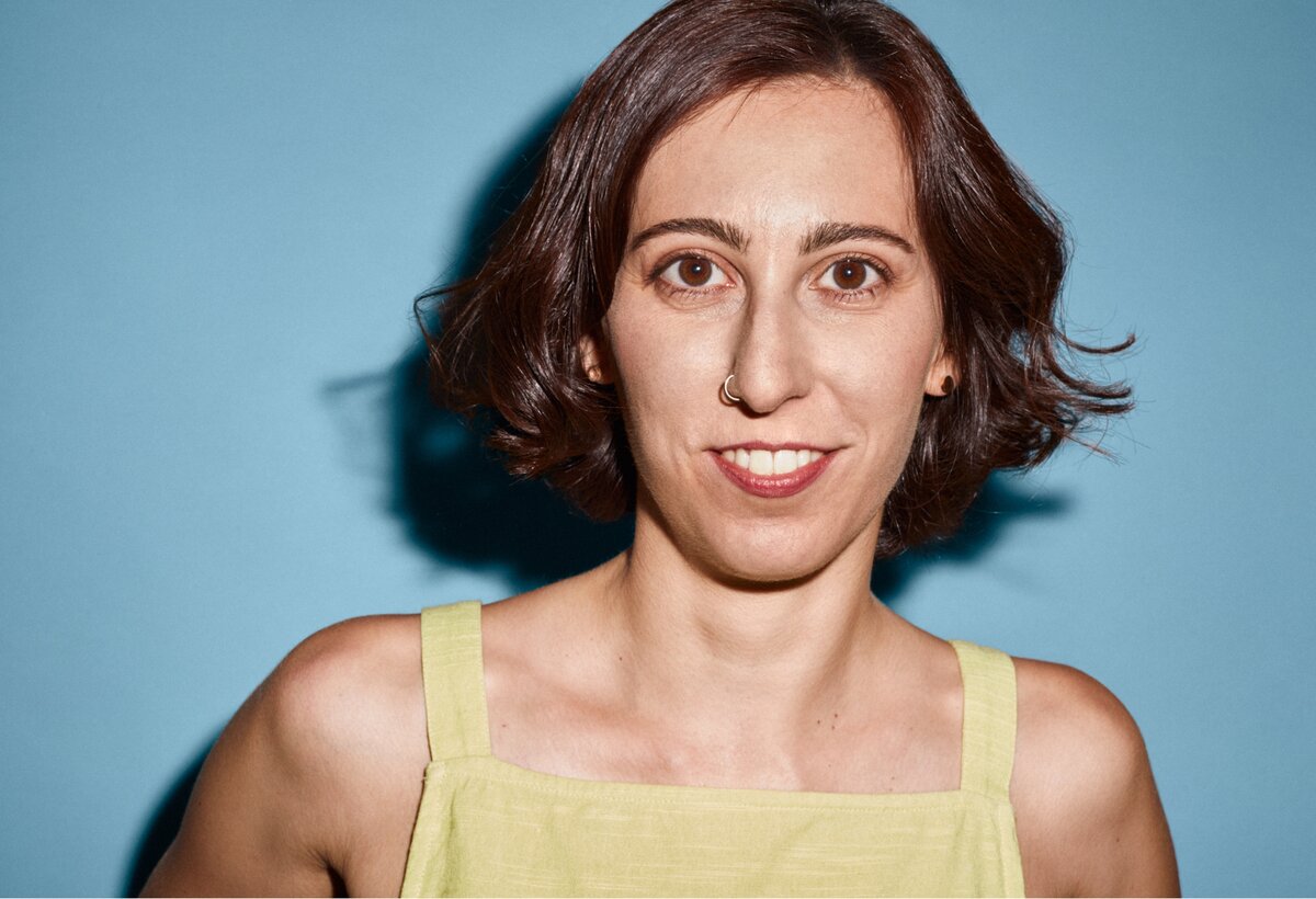 Eine Frau in gelbem T-Shirt steht vor einer blauen Wand | © Florian Käfmüller