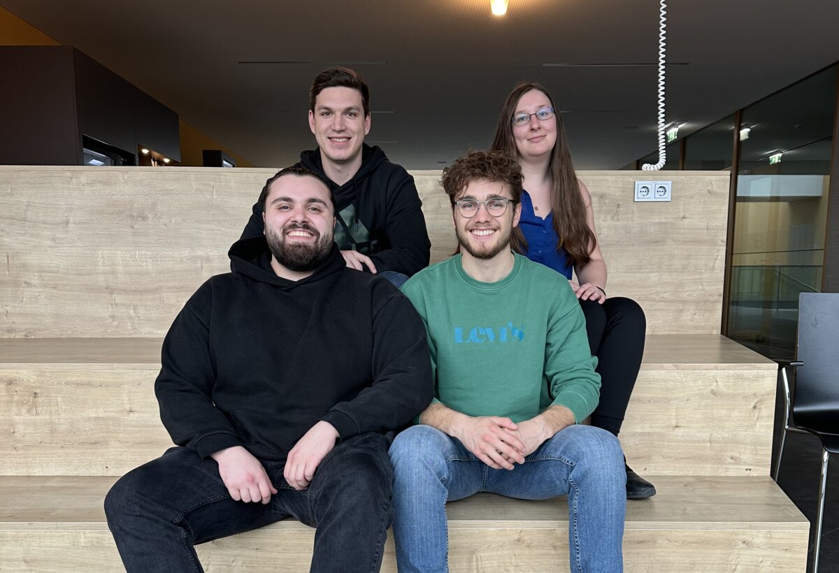 Selahattin Can Özyanik, Viktor Hirsch, Simon Lasser und Sabrina Aurenz (v. vorne li.) arbeiten gemeinsam an einem Studierendenprojekt. | © FHV Vier Student:innen sitzen auf einer Treppe und posieren. | © FHV