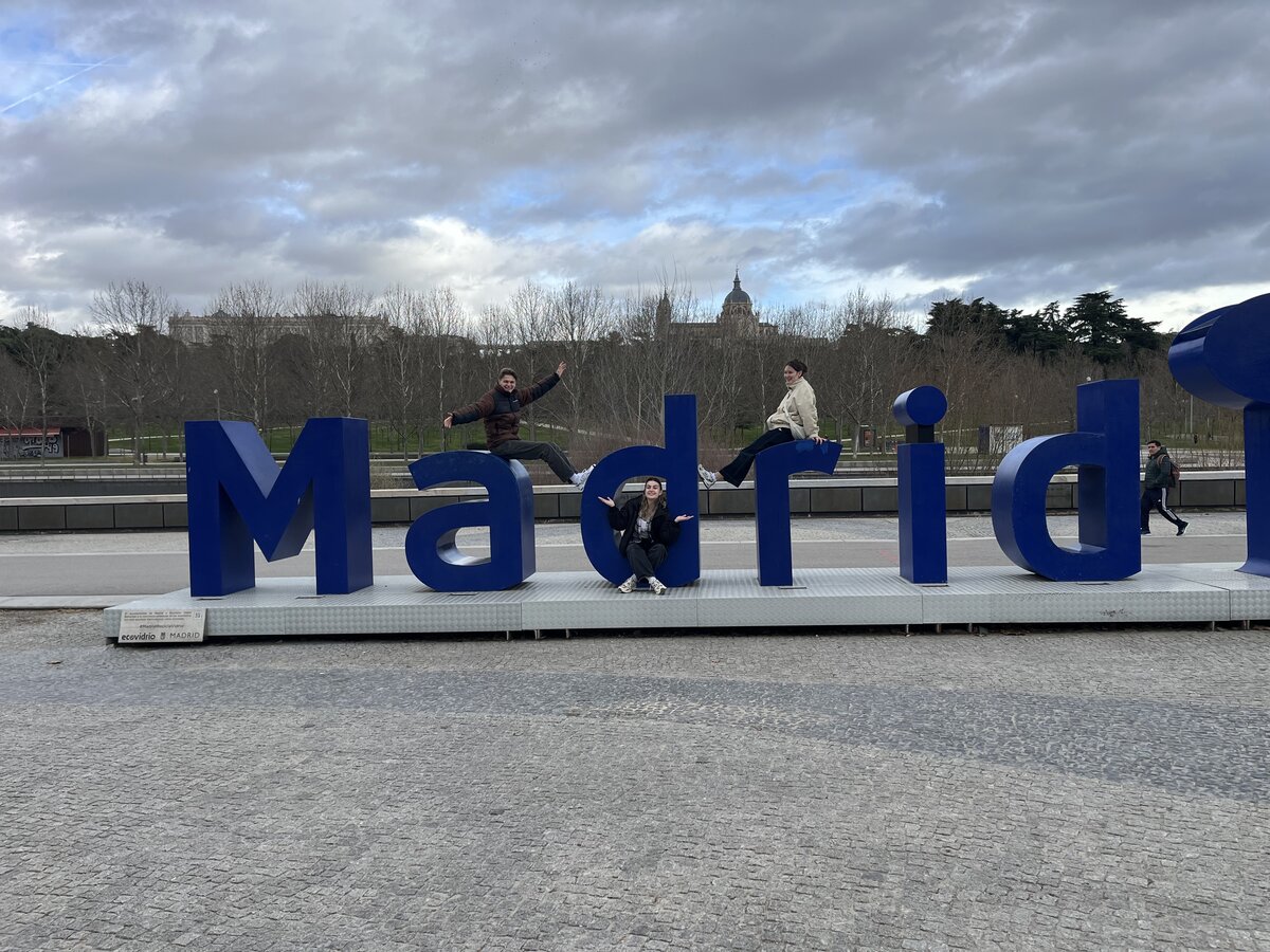 Lukas, Evin und Polyxeni posieren auf dem blauen Schriftzug der Stadt Madrid. | © FHV