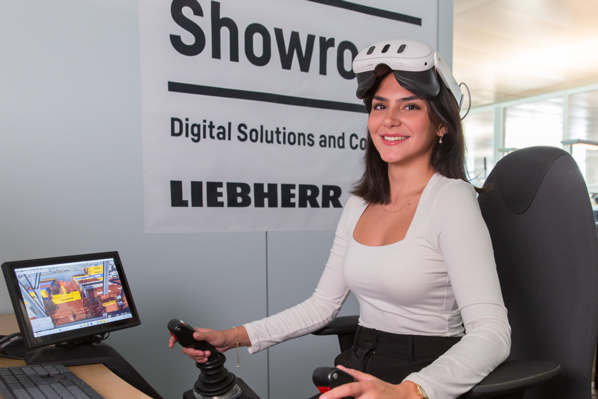 Die Studentin sitzt am Liebherr Trainingssimulator im Showroom. | © Liebherr in Nenzing