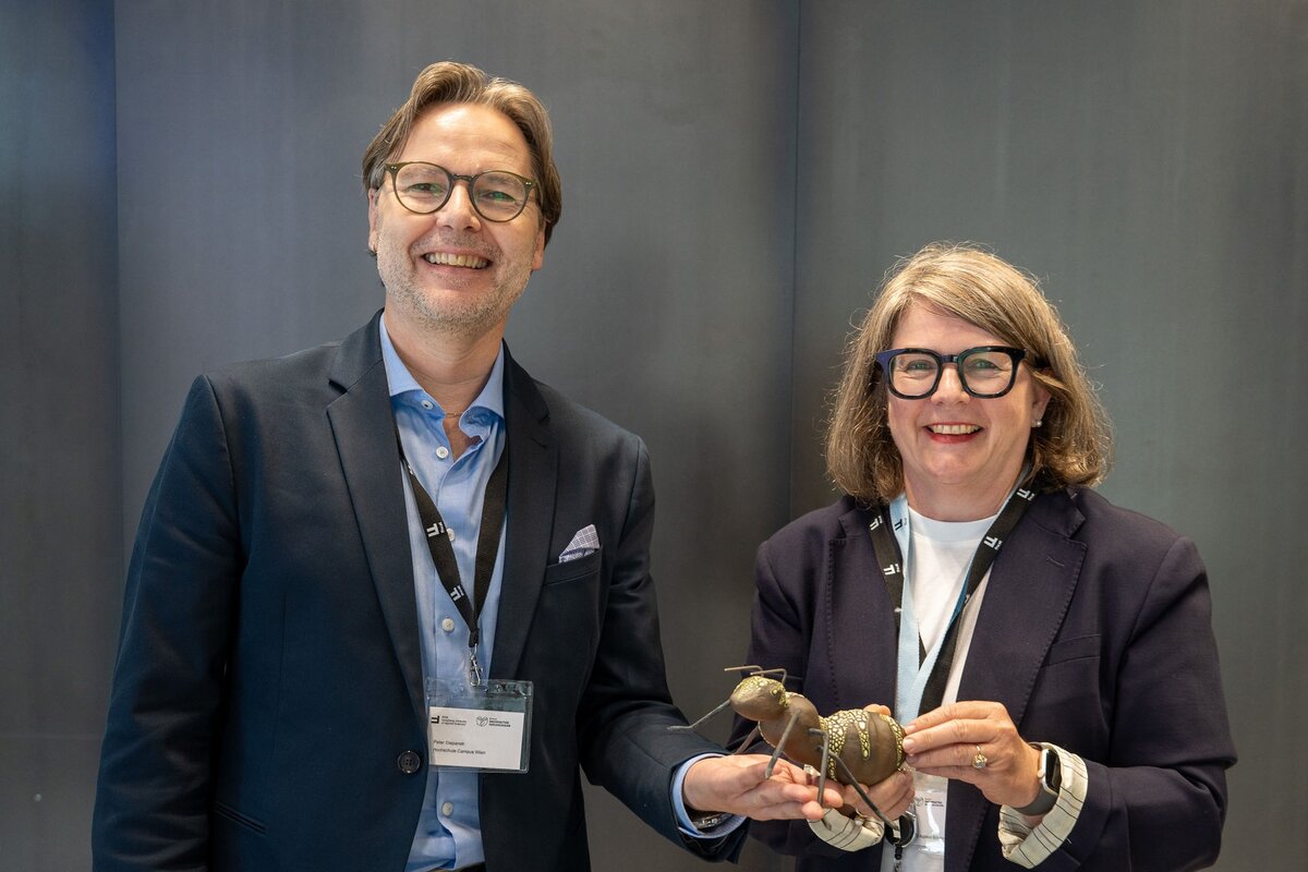 Peter Stepanek überreicht Beate Pawle eine aus Holz gefertigte Ameise. | © ilgs.at | BNH