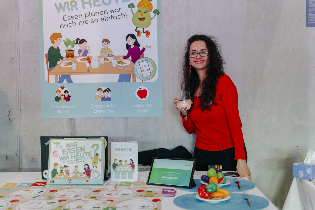 FHV-Alumna Tayla Fenkart steht vor dem MioKio Essensplaner | © Privat / Tayla Fenkart - detayle