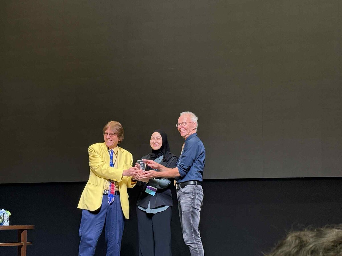 Zeynep Öztürk erhält Best Paper Award in Bankok auf internationaler E-Learning Konferenz. Übergabe des Awards auf einer Bühne. | © Privat