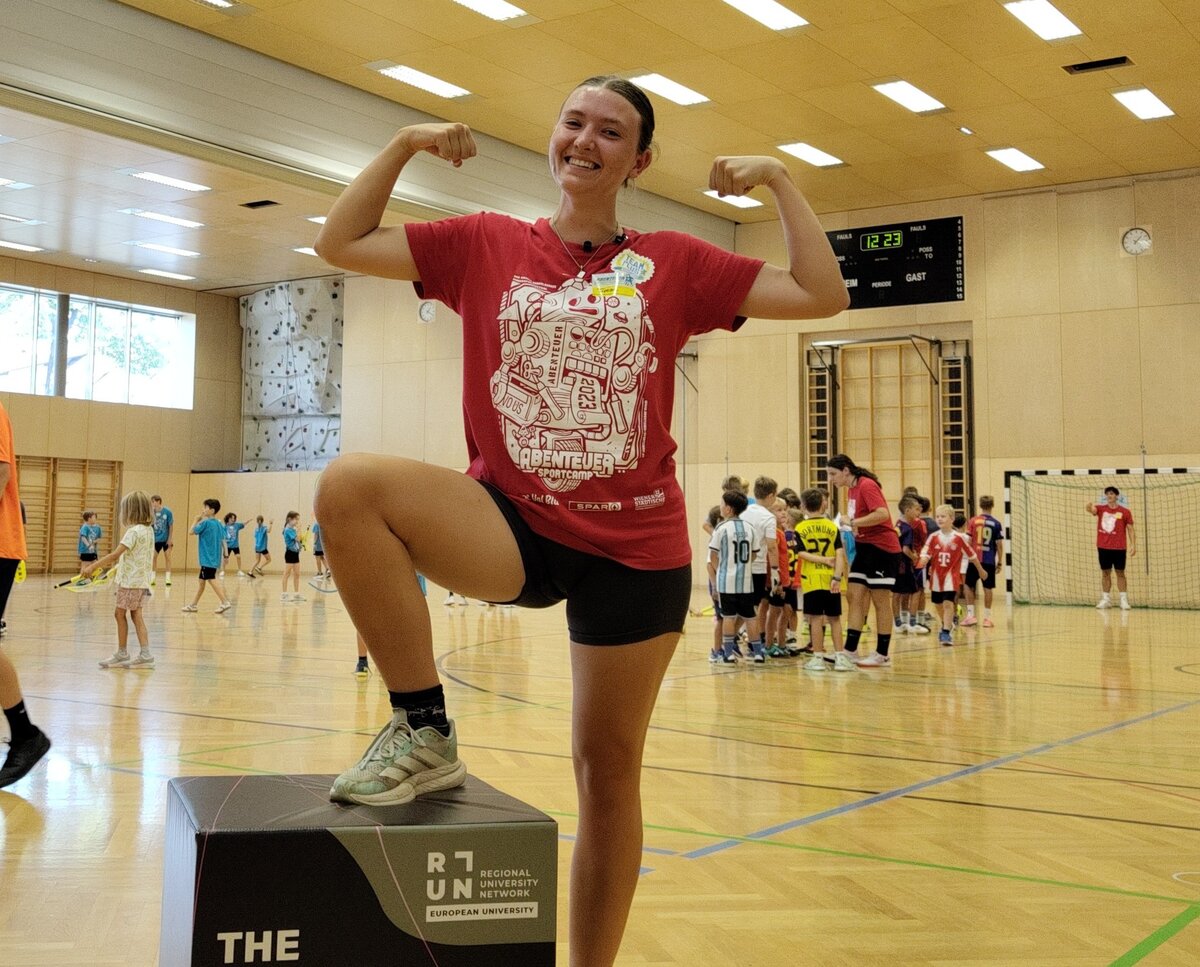 Die Studentin beim Sportcamp. Im Hintergrund spielende Kinder. | © FHV