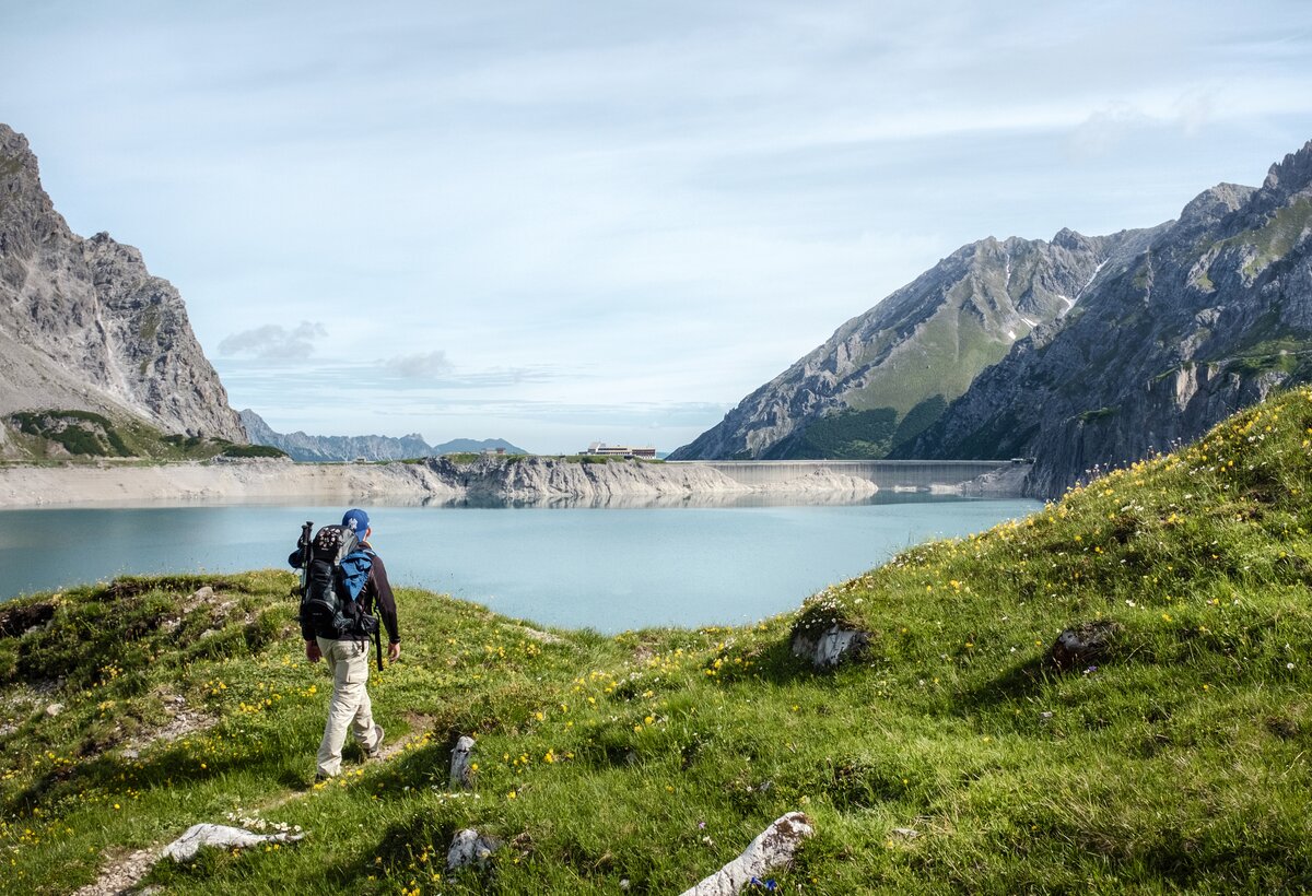 Lünersee Stausee mit Wanderer im Vordergrund und Douglashütte im Hintergrund | © Andreas Haller - Montafon Tourismus GmbH