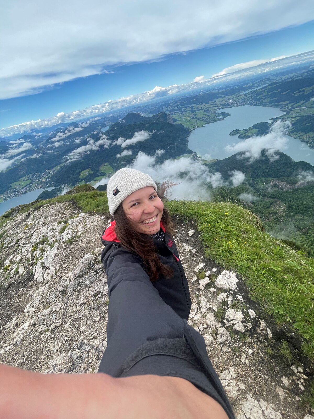 Valentina Angeli macht ein Selfie vor einer beeindruckenden Berglandschaft mit klaren Seen im Hintergrund; sie lächelt in die Kamera und wirkt entspannt und naturverbunden. | © privat