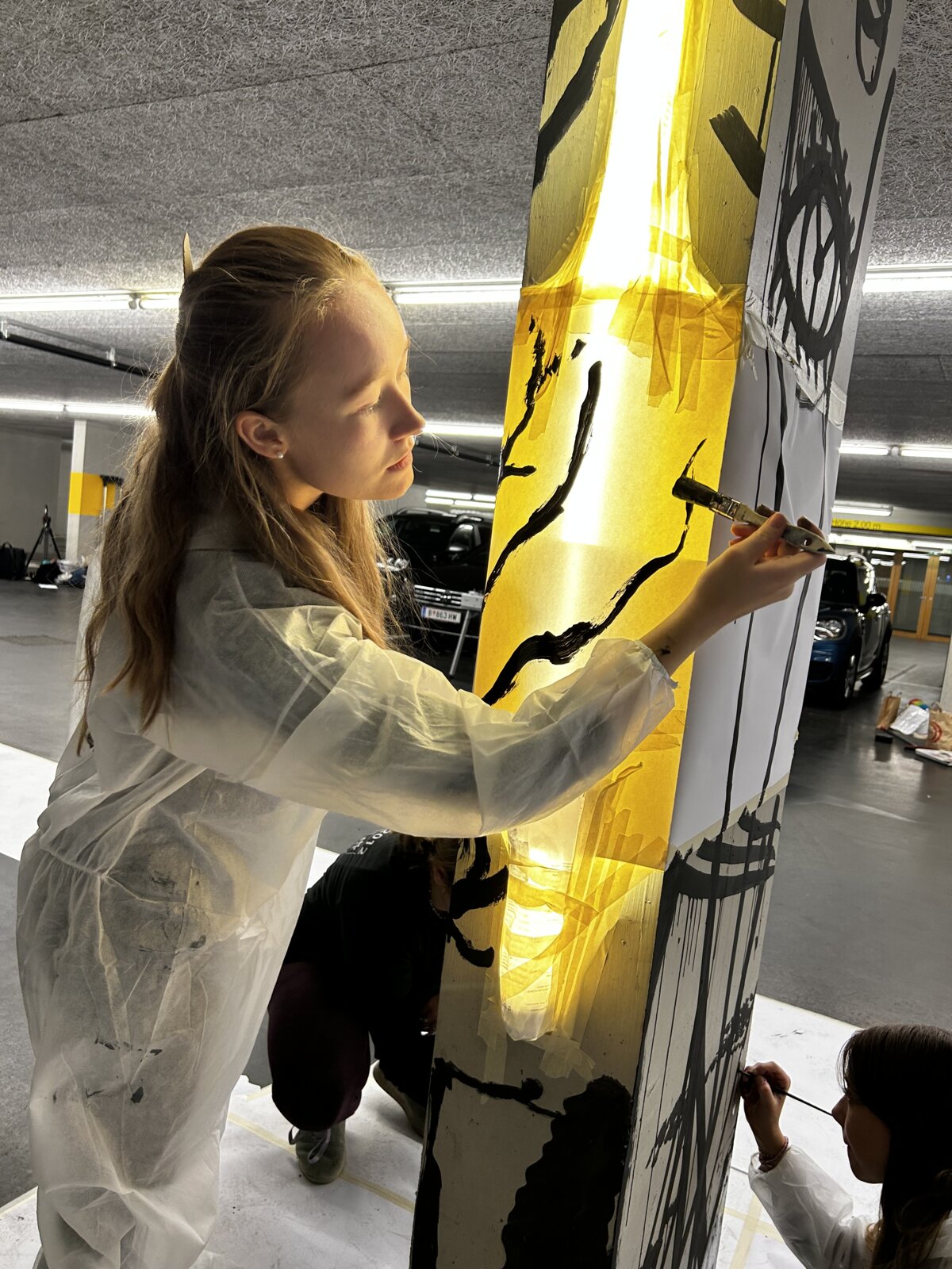 InterMedia Studentin malt eine Säule in der Tiefgarage gelb an | © ©fachbereich-gestaltung-fhv